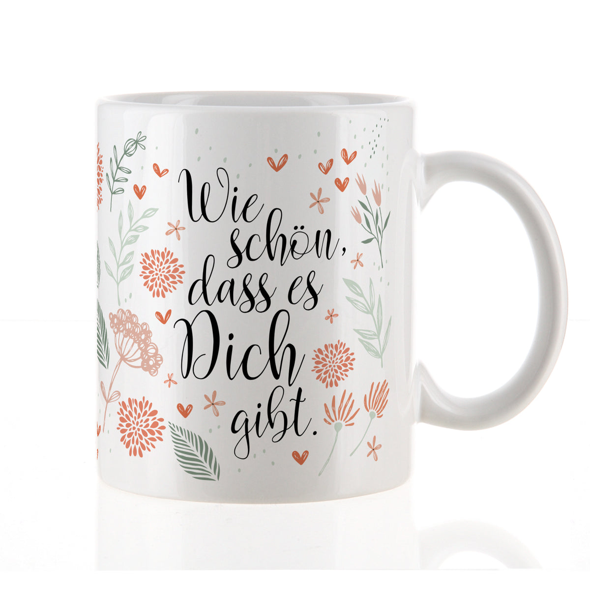 Nahaufnahme der weißen Tasse mit Blumenmuster und Spruch „Wie schön, dass es Dich gibt“ auf weißem Hintergrund.