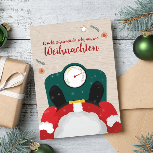 Lustige Weihnachtskarte mit Waage-Motiv und Geschenken auf Tisch, ideal für Weihnachtspost