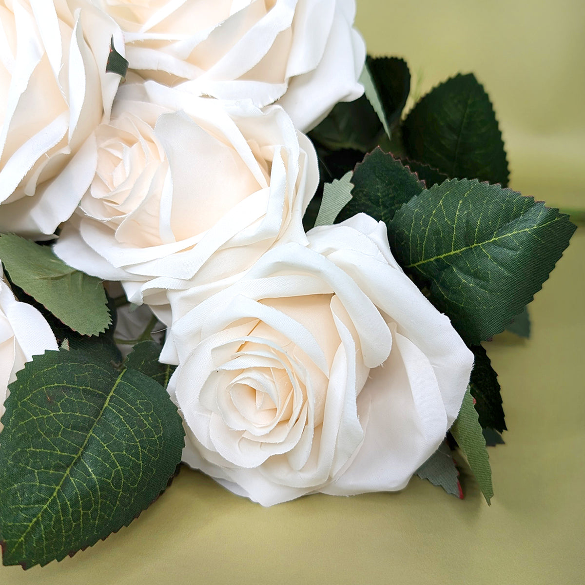 Detailansicht der Rosenblüten mit zartem Creme-Ton und realistischen Blättern