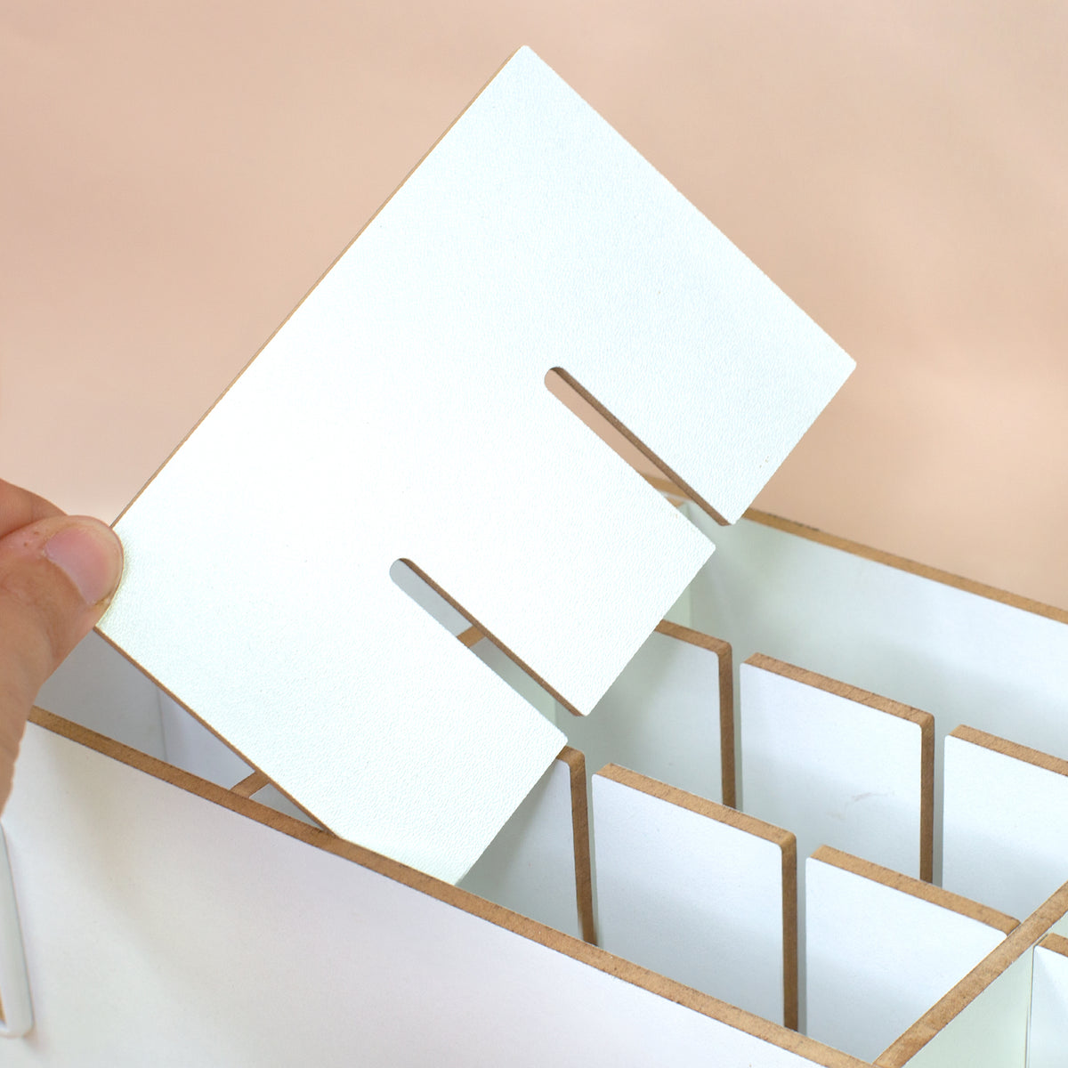 Detailansicht der Fächer und Trennstege im weißen Make-up Organizer aus Holz