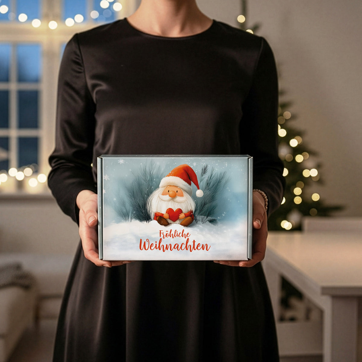 Geschenkbox Weihnachten mit Wichtel – von einer Person in beiden Händen gehalten, stimmungsvolle Szene