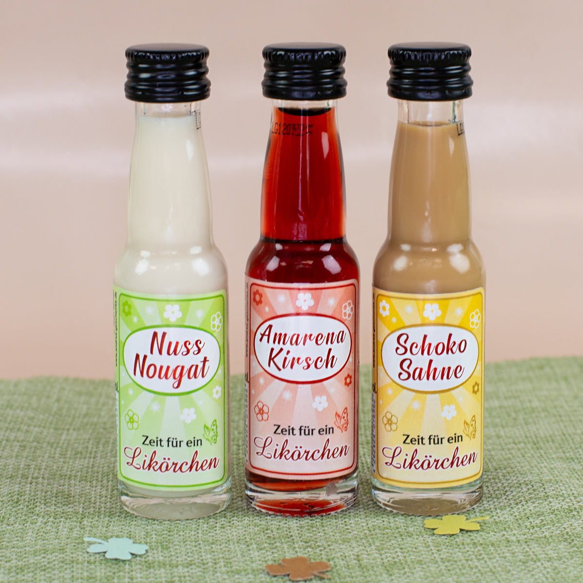 Drei Mini Likörflaschen Nuss-Nougat, Amarena-Kirsch und Schoko-Sahne als Set auf Tisch