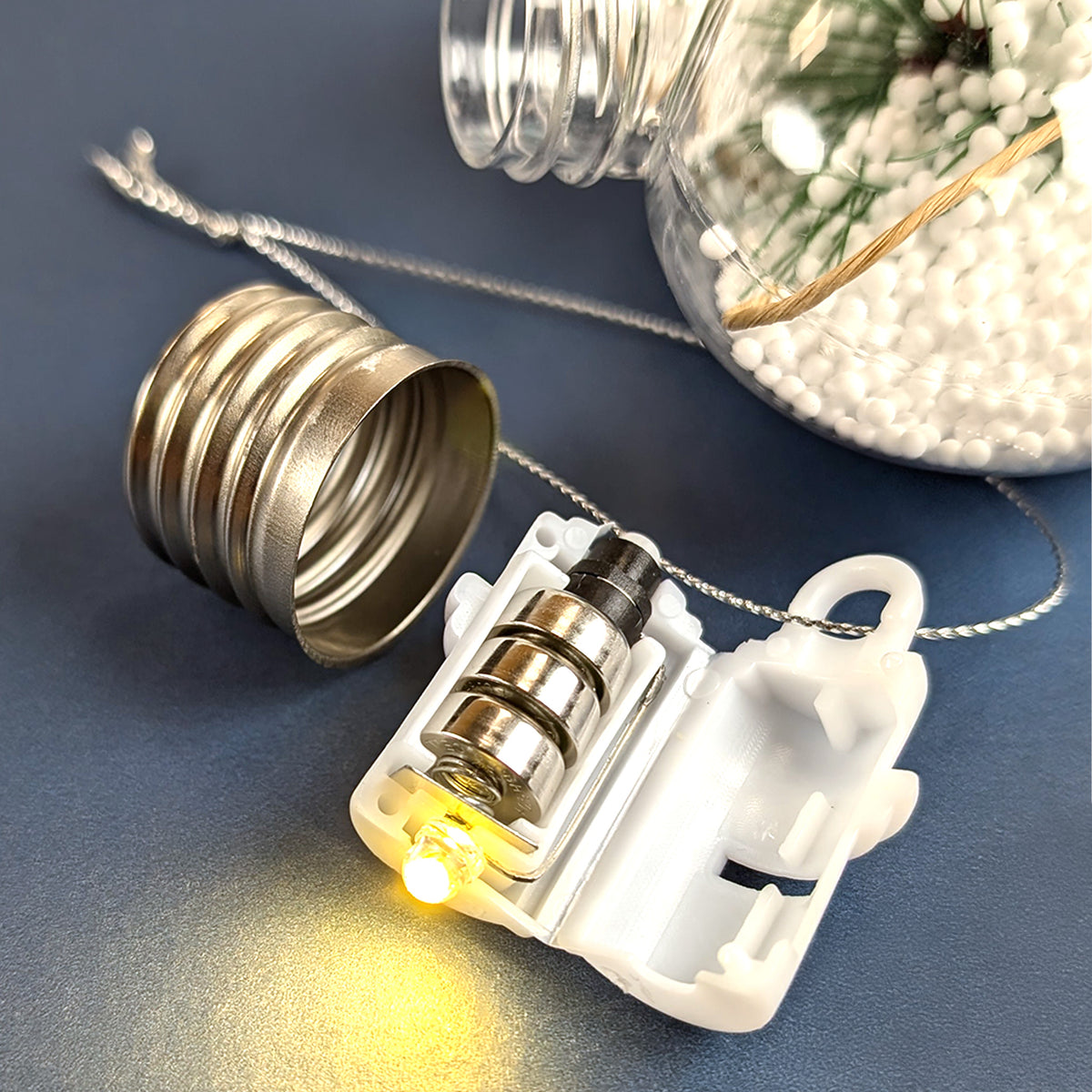 Geöffnete LED-Fassung mit warmweißem Lichtmodul und Batterieeinlage.