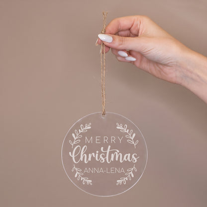 Hand hält runde Acryl Weihnachtsbaumkugel mit Juteband, „Merry Christmas“ Motiv und personalisiertem Namen Anna-Lena