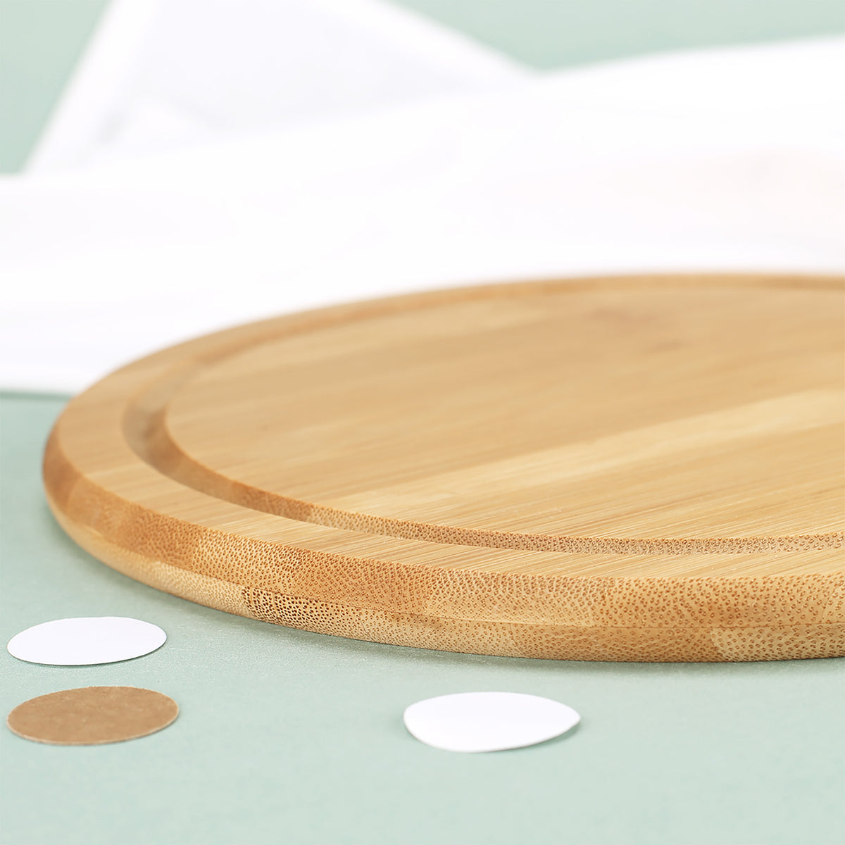 Detailaufnahme von Kante, Bambusmaserung und umlaufender Saftrille des runden Schneidebretts