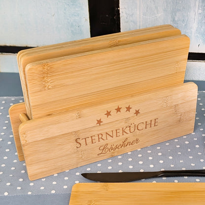 Bambusbrettchen-Set im Halter mit Gravur „STERNEKÜCHE“ und Name „Löschner“ auf gepunktetem Tuch