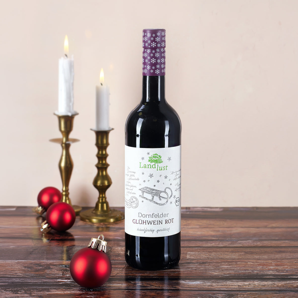 Flasche Landlust Dornfelder Glühwein Rot 0,75 l mit 11 Prozent Alkohol in weihnachtlicher Dekoration mit Kerzen und Christbaumkugeln