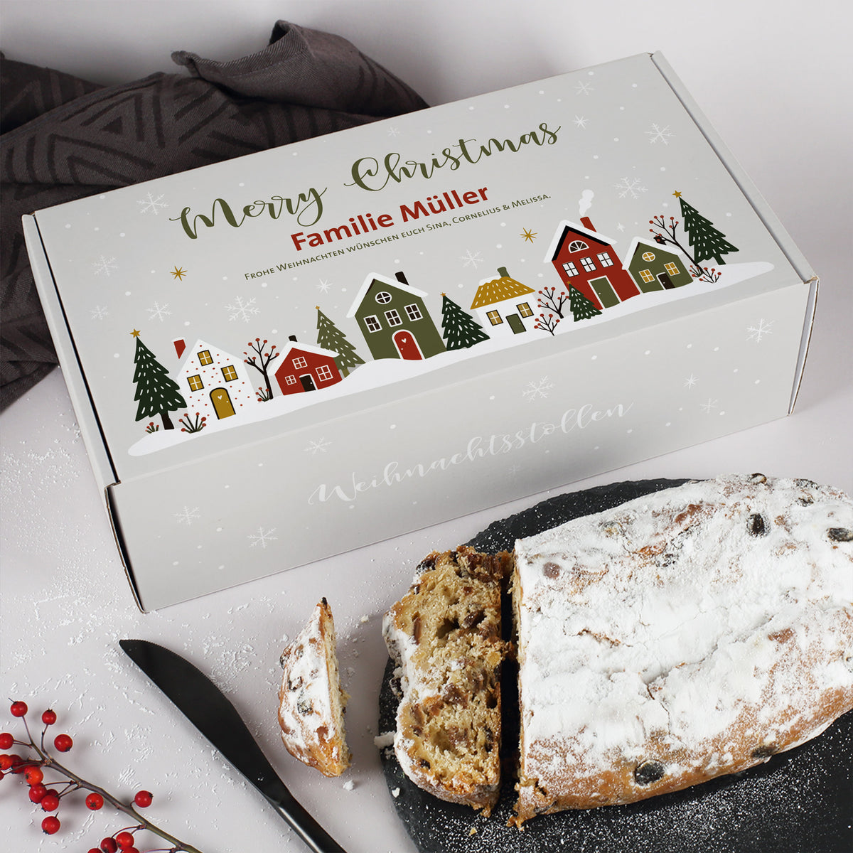 Weihnachtsstollen mit personalisierter Merry Christmas Geschenkverpackung für Familie Müller und angeschnittenen Stollenscheiben