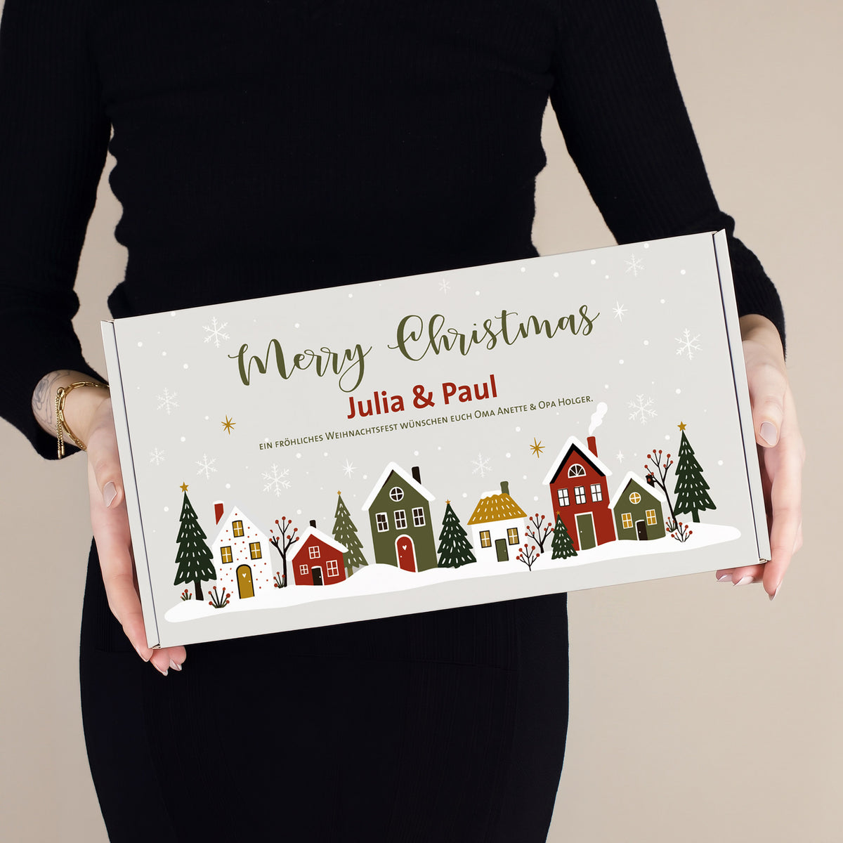 Frau hält personalisierte Geschenkbox für Weihnachtsstollen mit Merry Christmas Motiv, Namen Julia und Paul sowie Wunschtext