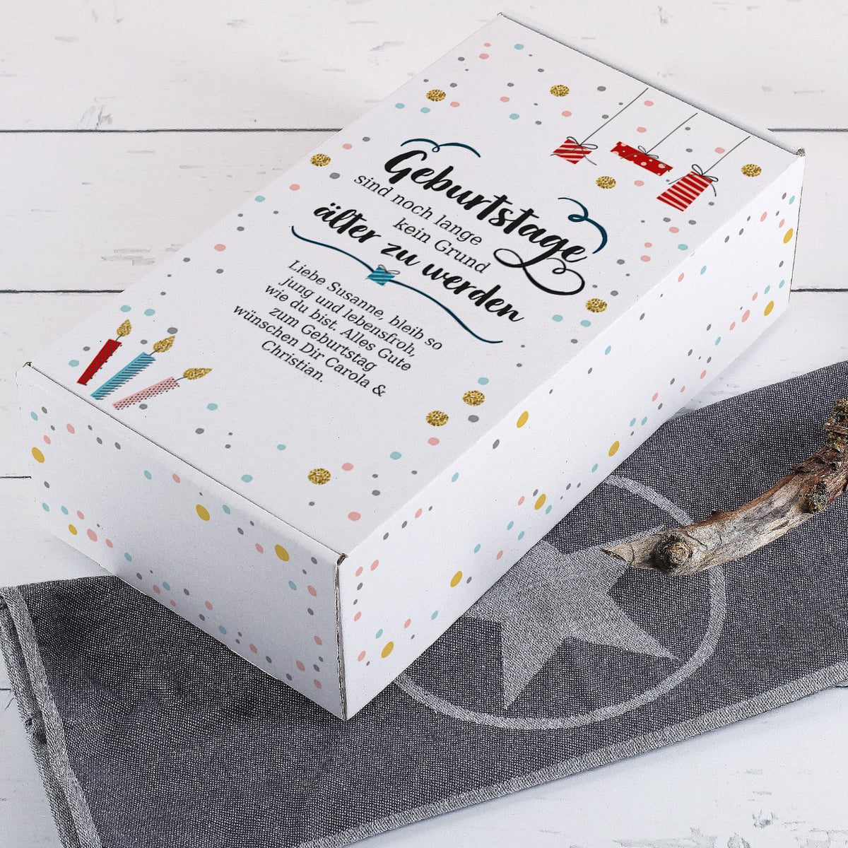 Geschenkbox aus Pappe mit Aufdruck "Geburtstage sind noch lange kein Grund älter zu werden" und Wunschtext