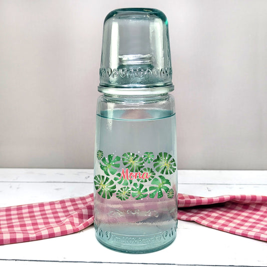 Personalisierte Karaffe mit Monstera-Motiv und Name – frontal auf Tisch
