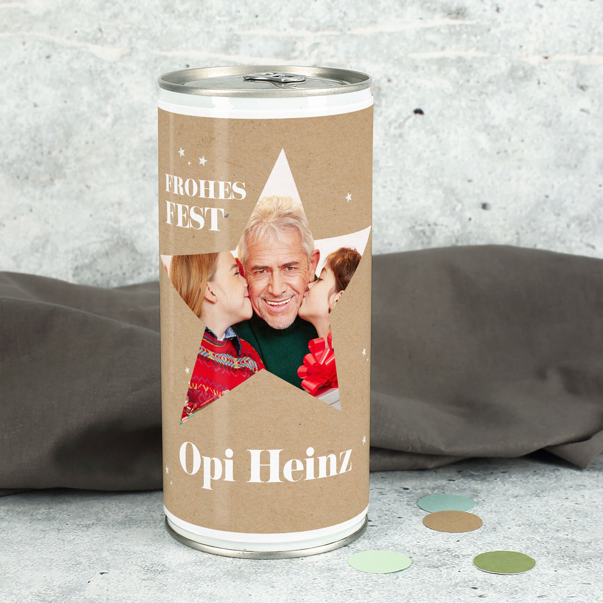 Weihnachtsbierdose mit großem Stern-Ausschnitt und eingedrucktem Familienfoto sowie Name „Opi Heinz“, winterliche Deko im Hintergrund.