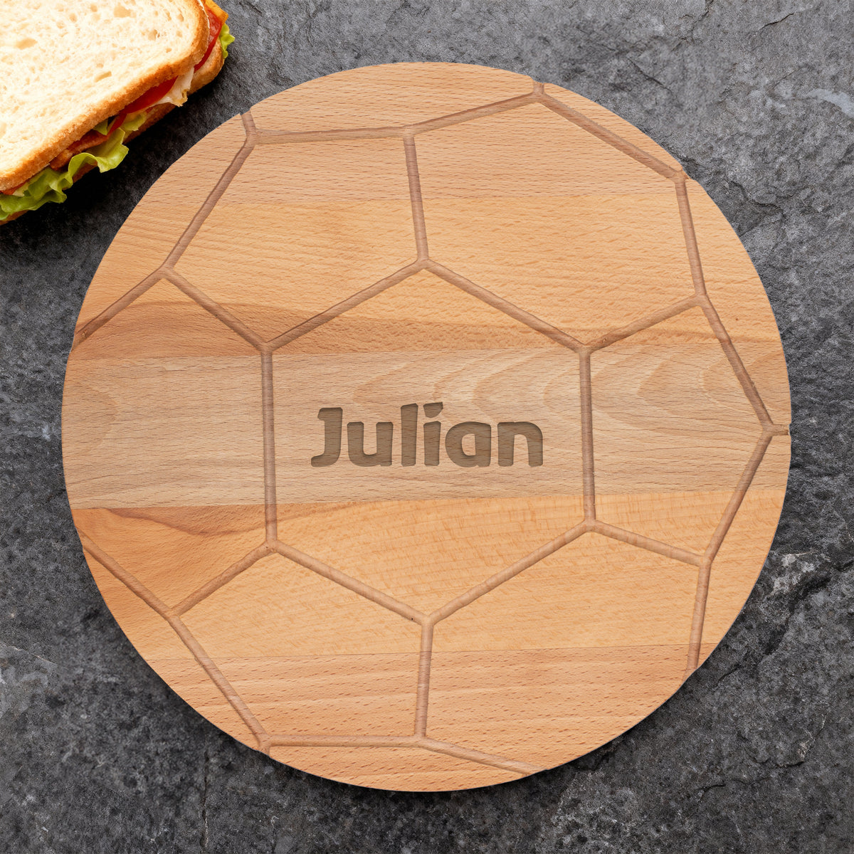 Fußball-Brettchen aus Buchenholz mit Namensgravur Julian auf dunkler Steinfläche