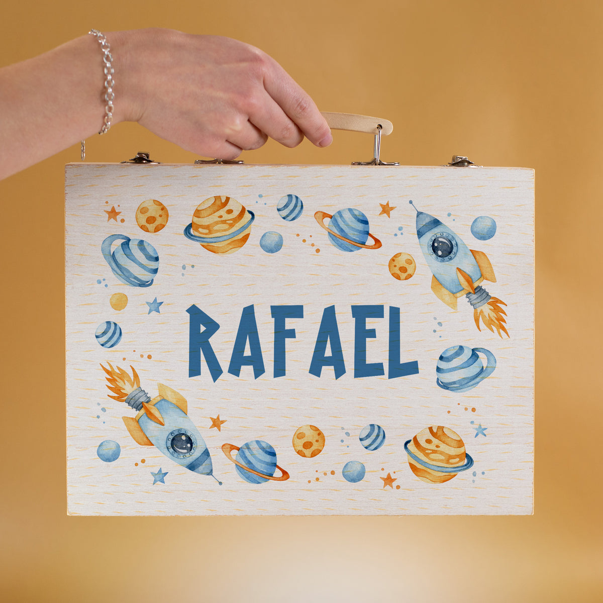 Personalisierter Kinder-Malkoffer mit Name Rafael und Weltall-Motiv – Hand hält den Koffer