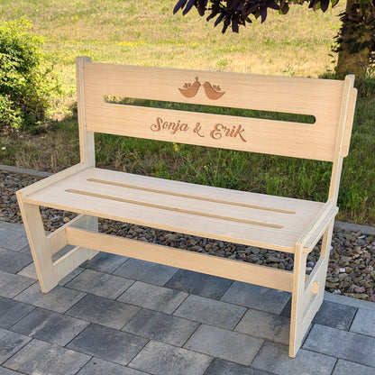 Personalisierte Holzbank mit Gravur "Sonja & Erik" und Vogelmotiv auf Terrasse im Grünen