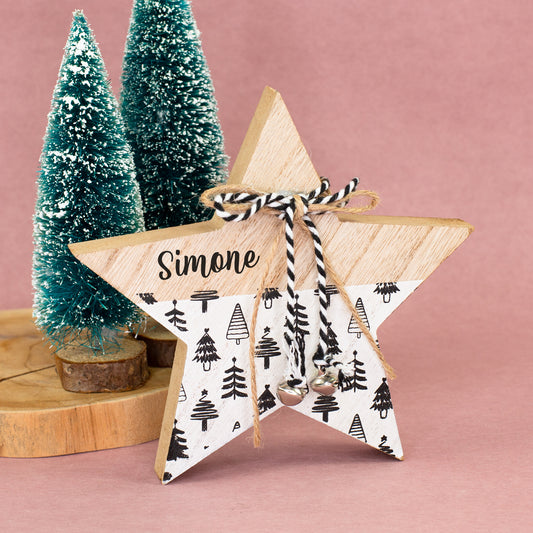 Personalisierter Deko-Stern aus Holz mit Name Simone vor kleinen verschneiten Weihnachtsbäumen