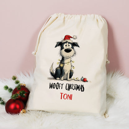 Großer Geschenksack mit Hundemotiv „Woofy Christmas – Toni“, dekoriert mit roten Weihnachtskugeln und Tannenzweig