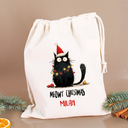 Personalisierter Geschenksack mit Aufdruck „Meowy Christmas – Milan“, Tannenzweige und Zimtstangen im Hintergrund