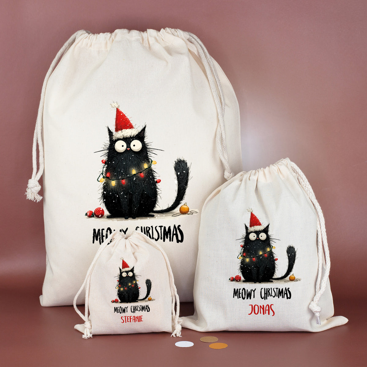 Drei Baumwoll-Geschenksäcke in unterschiedlichen Größen mit Katzenmotiv „Meowy Christmas“, personalisiert mit verschiedenen Namen