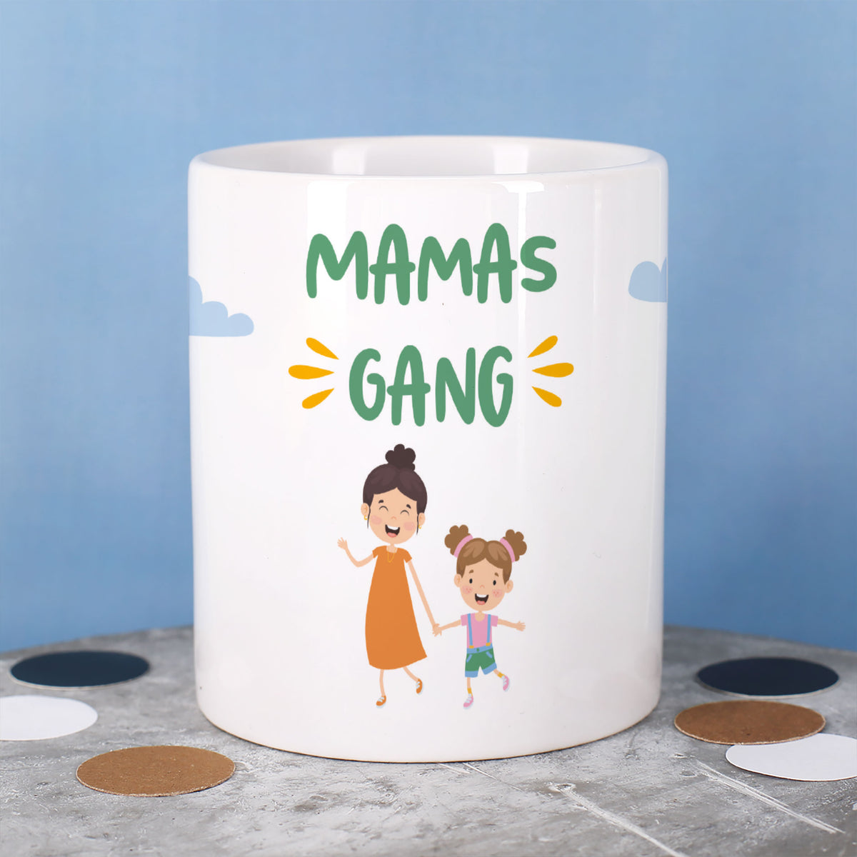 Tasse mit Text „Mamas Gang“ und zwei Figuren: eine Mutter mit Kind, vor blauem Hintergrund
