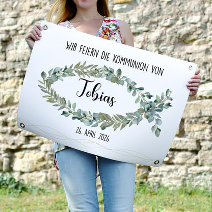 Poster-Banner mit christlichem Eukalyptus-Fischmotiv, Name „Tobias“ und Datum „26. April 2026“. Das Banner hängt über einem festlich gedeckten Tisch mit Kuchen, Obst und Blumen.