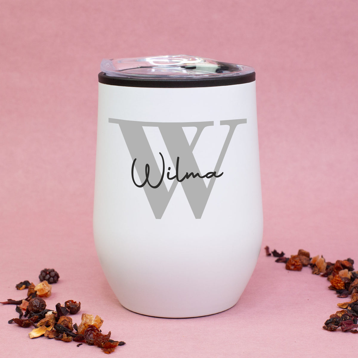 Variante: Weißer Thermobecher mit Initiale W und Name Wilma, auf rosa Hintergrund mit Teemischung dekoriert