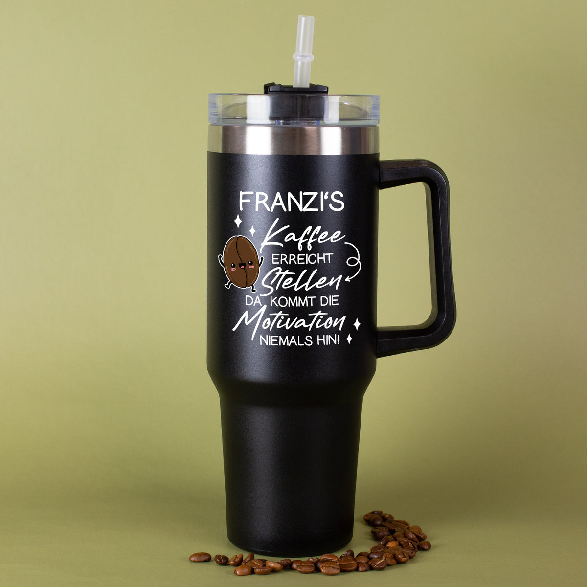 Thermobecher in Schwarz mit Kaffee-Spruch und Name vor grünem Hintergrund mit Kaffeebohnen dekoriert