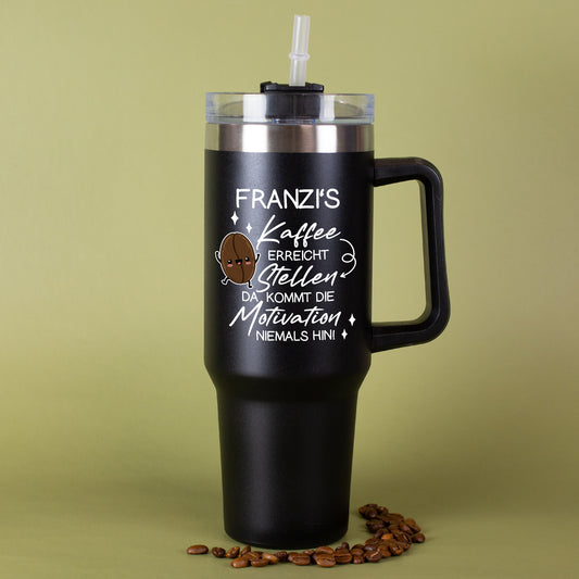 Thermobecher in Schwarz mit Kaffee-Spruch und Name vor grünem Hintergrund mit Kaffeebohnen dekoriert