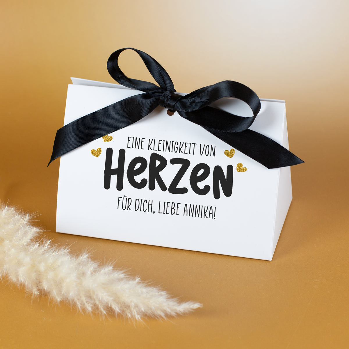 Personalisierte Geschenkverpackung mit Aufdruck „Eine Kleinigkeit von Herzen“ und Wunschtext, geschlossen mit schwarzer Schleife