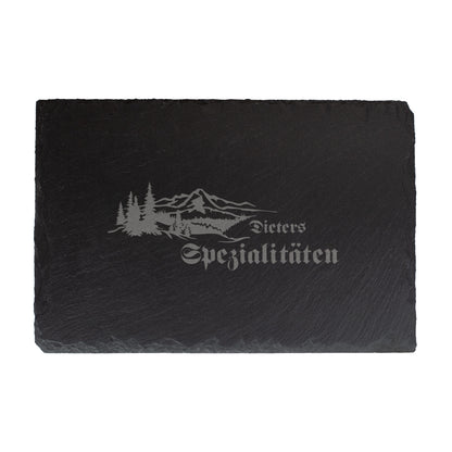 Personalisierte Schieferplatte 30x20 cm mit Gravur „Dieters Spezialitäten“ und Wald-Berge-Motiv, freigestellt auf weißem Hintergrund.