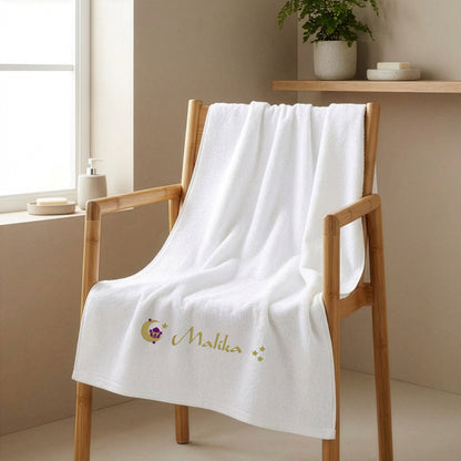 Weißes Badetuch mit orientalischem Motiv Moschee Mond Sterne und Name Malika bestickt auf Holzstuhl im Badezimmer