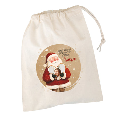 Naturfarbener Baumwollbeutel mit Weihnachtsmann-Motiv, Foto im Herz und Text „Du bist nicht nur zu Weihnachten besonders Kiara“, freigestellt – personalisierte Geschenkverpackung.