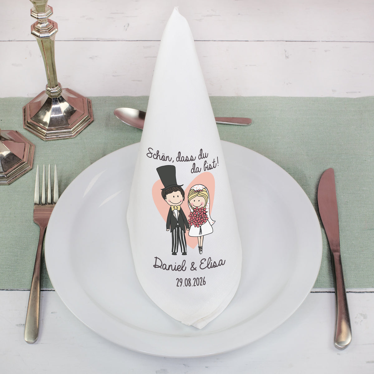 Stoffserviette Hochzeit personalisiert gefaltet auf Teller mit Besteck und Brautpaar Design
