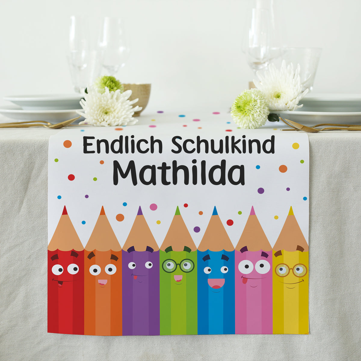 Ansicht der Buntstift-Figuren mit lachenden Gesichtern und dem Schriftzug mit dem personalisierten Namen an einem Ende