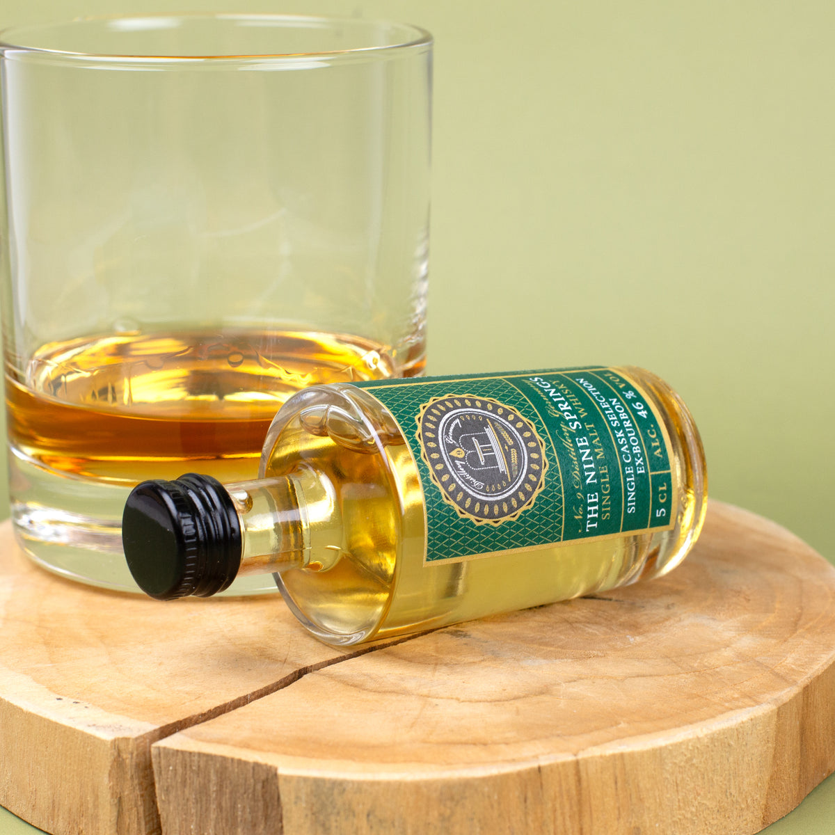The Nine Springs Whisky Miniaturflasche Ex-Bourbon liegend vor Glas