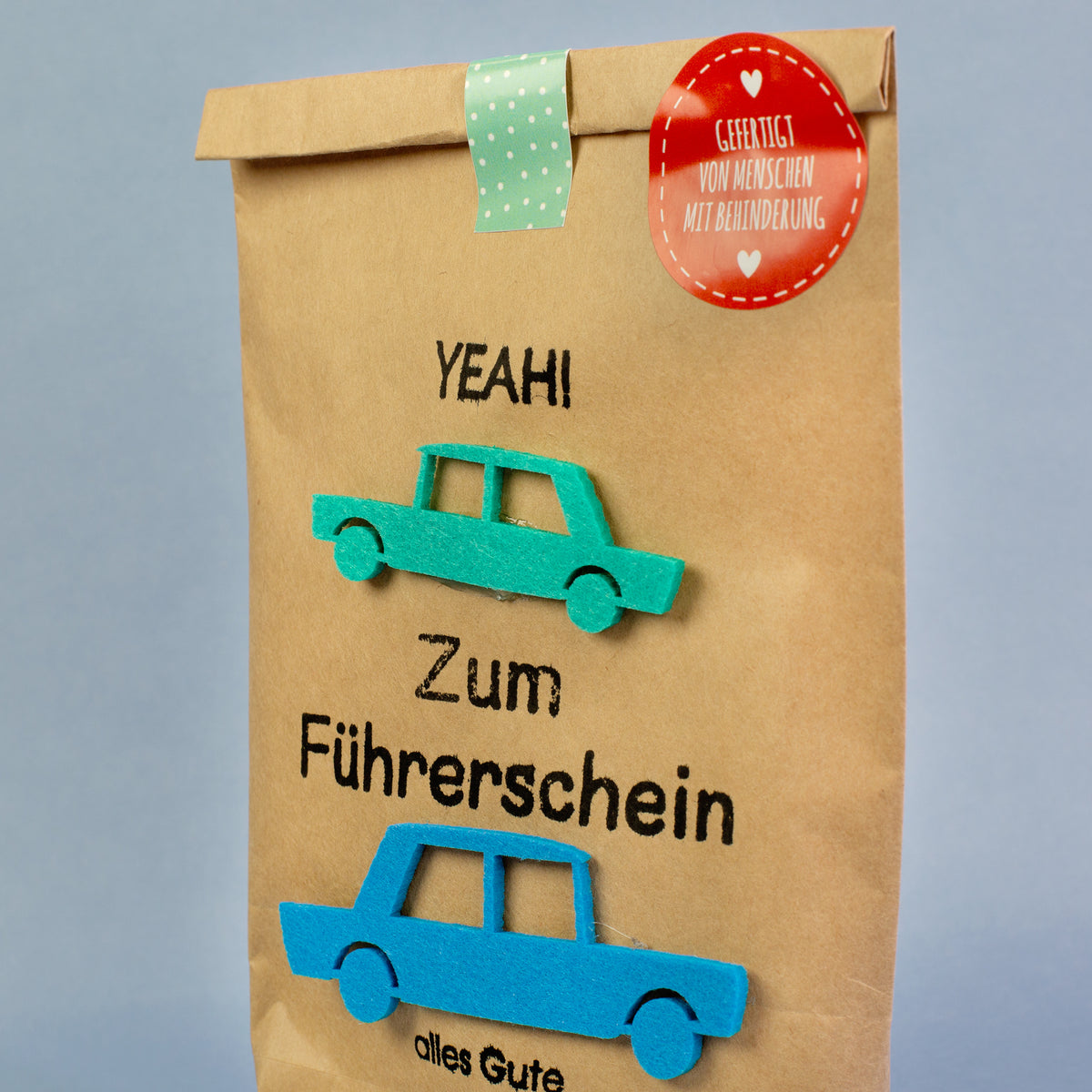 Geschenk-Wundertüte Führerschein mit Autos aus Filz und Aufkleber „Gefertigt von Menschen mit Behinderung“